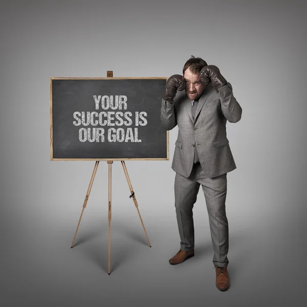 Your success is our goal text on blackboard with businessman
