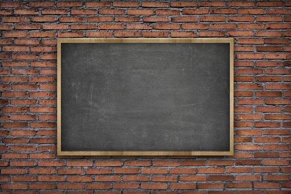 Black blank blackboard with wooden frame on brick wall background