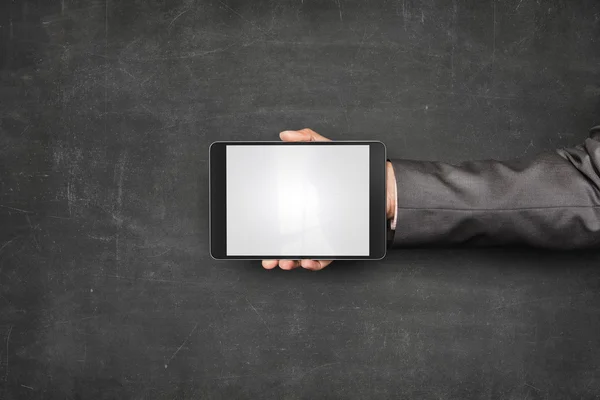 Businessman hand holding tablet front of blackboard