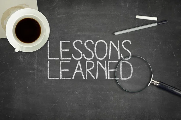 Lessons learned concept on black blackboard