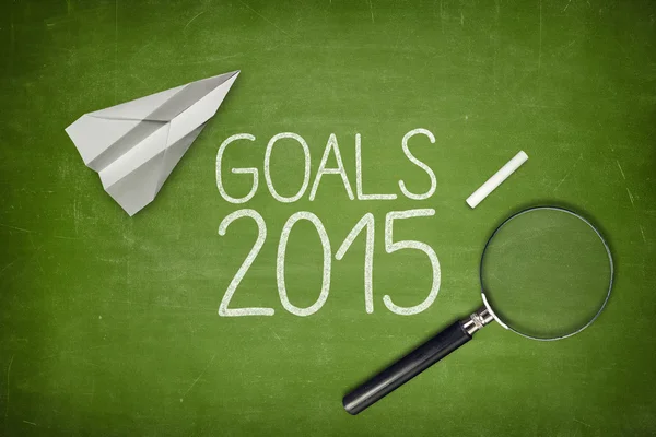 Goals 2015 concept on green blackboard with empty paper sheet