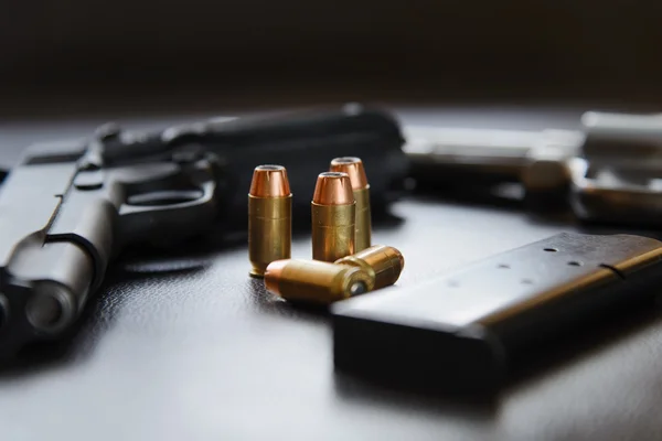 .45 Caliber hollow point bullets near handgun and magazine on le