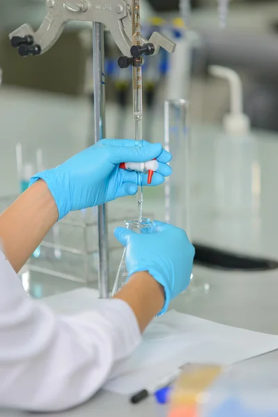 The woman who\'s the scientist is demonstrate the titration technique