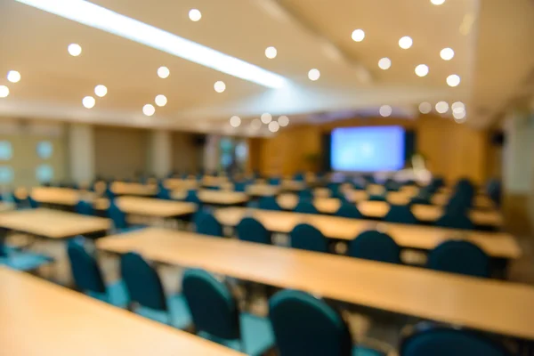 Empty meeting or conference room blurred for background.