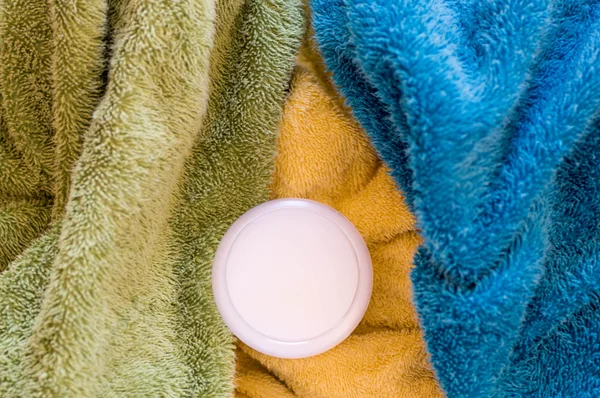 Upper view of measuring cup with liquid detergents on towels
