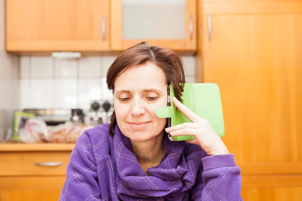 Women over 40 with telephone in the kitchen