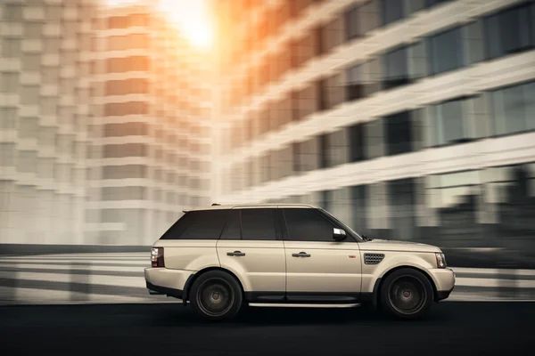 Premium car Land Rover Range Rover fast drive on road in the city at daytime