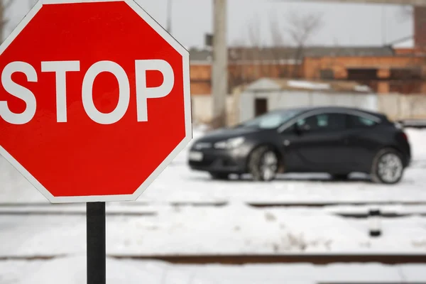 Road stop sign with car at winter daytime