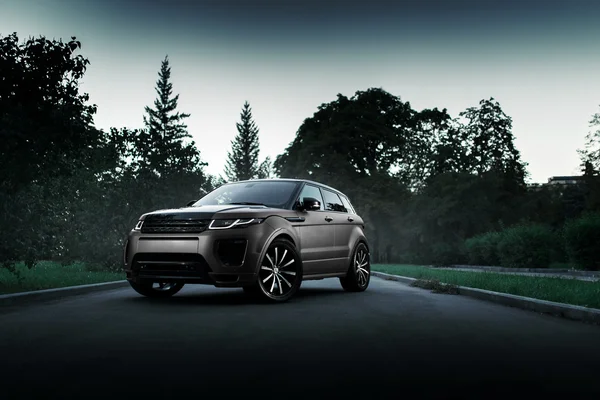 Car Land Rover Range Rover Evoque standing on asphalt road in city Moscow at sunset