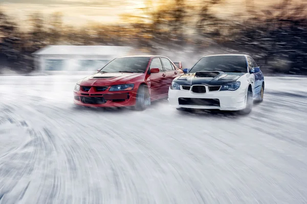 Two cars fast drive race speed at winter impreza  and lancer evolution