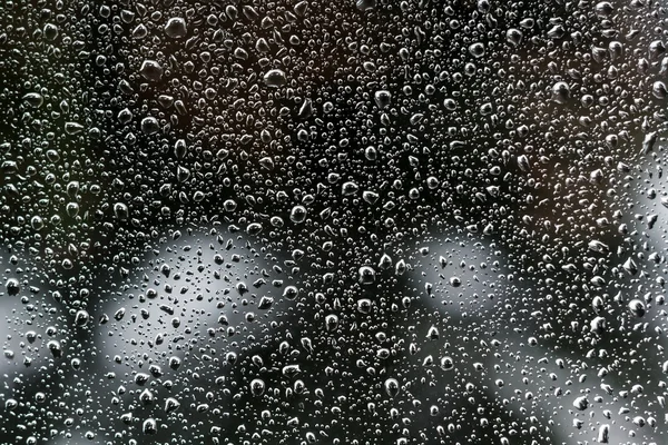 Rain water drops on transparent wet glass