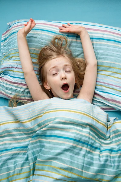 Little girl 5 years old with long blonde hair smiling in his sleep