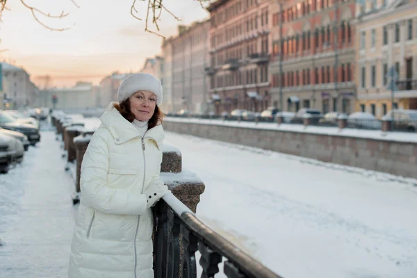 Beautiful woman 50 years old walking on the snowy city