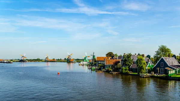 View from the Zaan River of Dutch Windmills and Historic Houses at the historic village of Zaanse Schans and Zaandijk in the Netherlands