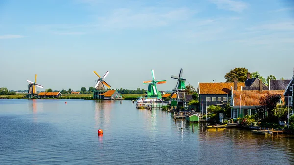View from the Zaan River of Dutch Windmills and Historic Houses at the historic village of Zaanse Schans and Zaandijk in the Netherlands