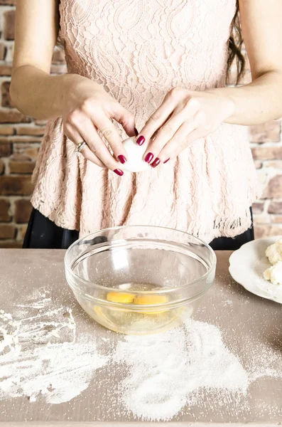 Woman in kitchen beating eggs