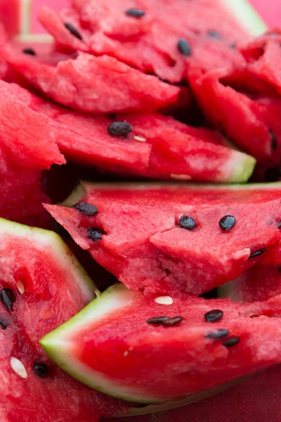 A ripe watermelon with black seeds sliced.