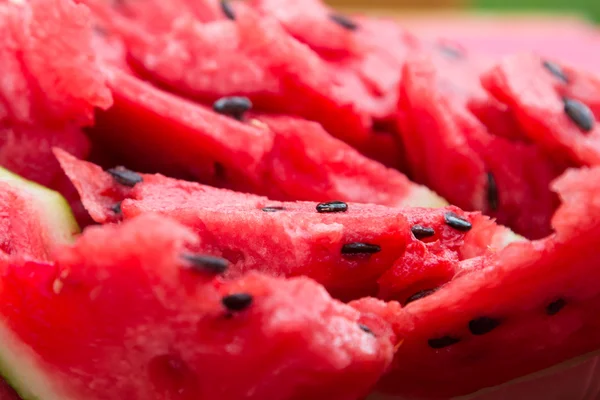 A ripe watermelon with black seeds sliced.