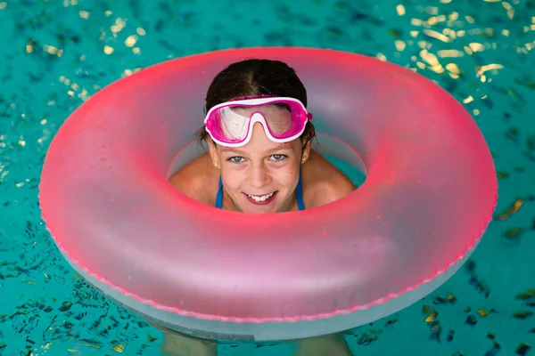 Funny girl in pink goggles in the swimming pool