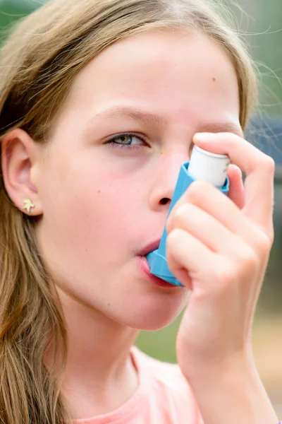 Girl having asthma using asthma inhaler for being healthy