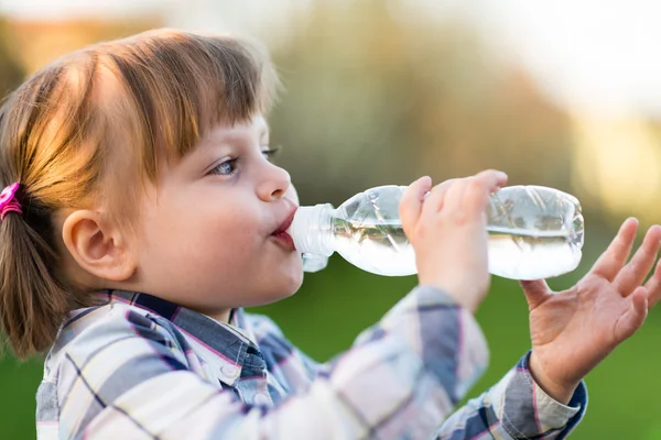 Portrait of little girl drinking water outdoor