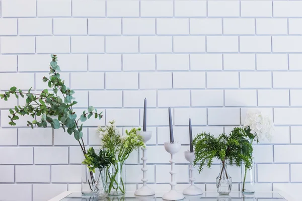 Brick wall interior with cafe table Candles, plant and vase of f