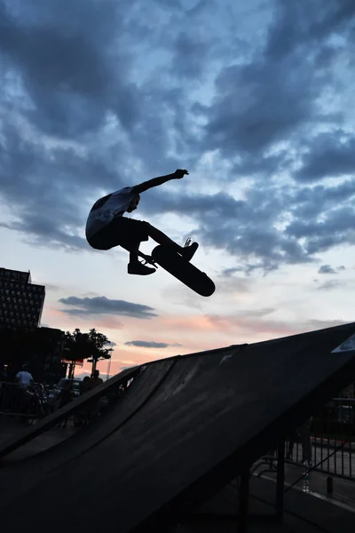 Skateboarding as extreme and fun sport. Skateboarder doing a trick in a city skate park.