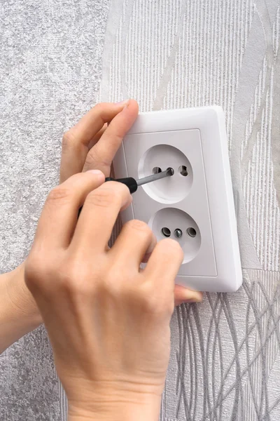 Installing a wall power socket with screwdriver