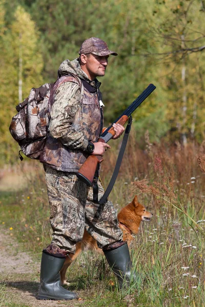Hunter with a dog in the forest