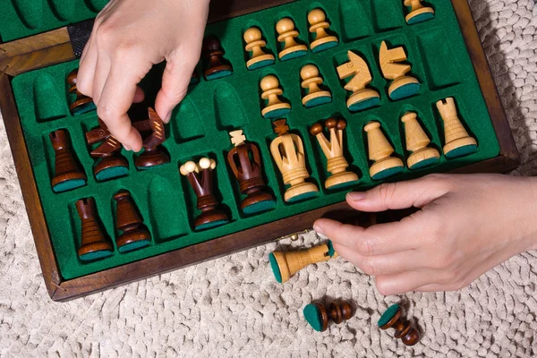 Hands putting the chess pieces in box after game