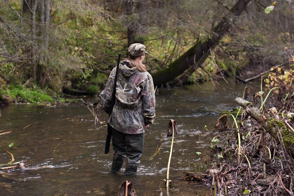 Woman hunter crossing the river