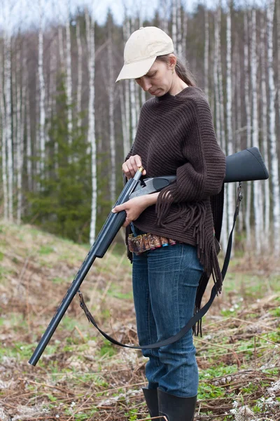 Woman hunter loading shotgun on the hunting