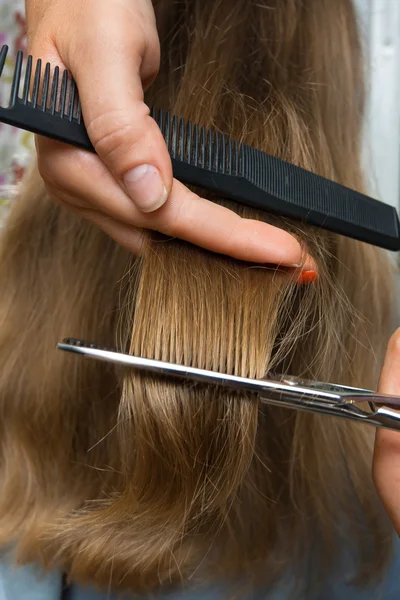 Trimming hair with scissors and comb