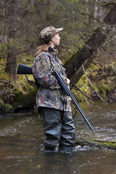 Woman hunter looking out for prey on the forest river