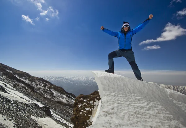 Man standing on a snow cornice in mountain sunrise