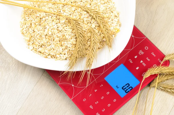 Dish of oatmeal on electronic kitchen scales
