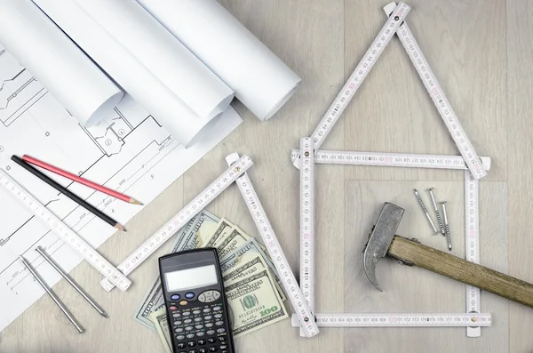 White meter tool forming a house and engineering tools on wooden