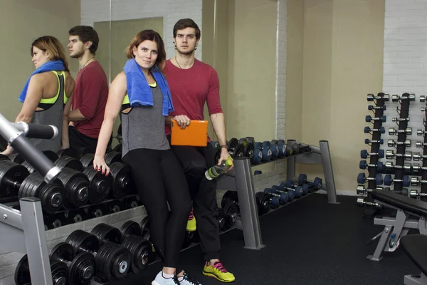 Beautiful sports fitness couple in the gym. Fitness instructors with additional equipment