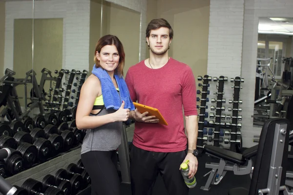 Beautiful sports fitness couple in the gym. Fitness instructors with additional equipment