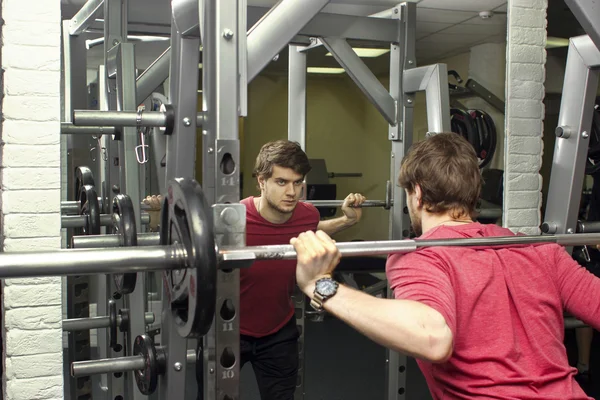 Fitness athletic trainer shows exercises with foarm roll, ball in gym.