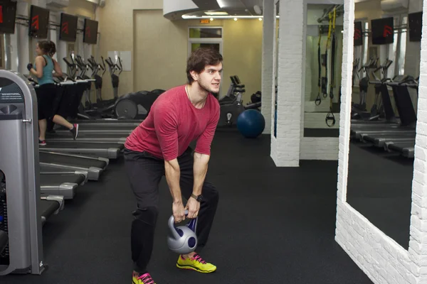 Fitness athletic trainer shows exercises with foarm roll, ball in gym.