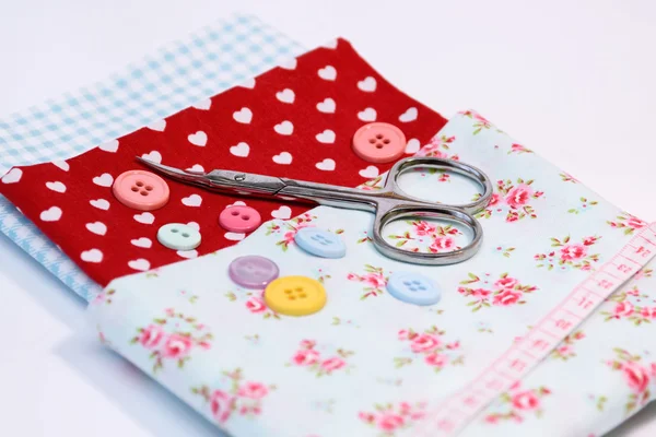 Sewing tools with various vintage fabric background with scissors and buttons