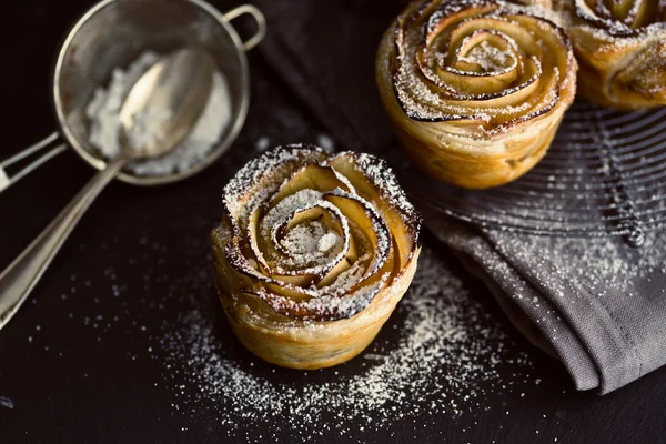 Mini apple roses puff pastry with icing sugar.