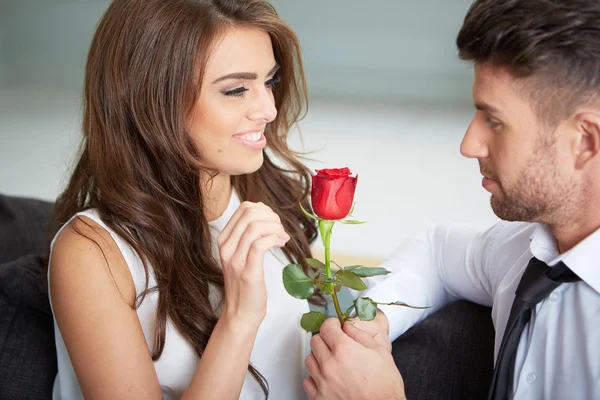 Portrait of two young people holding a rose