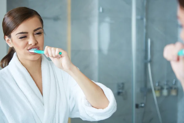 Young pretty woman brushing teeth