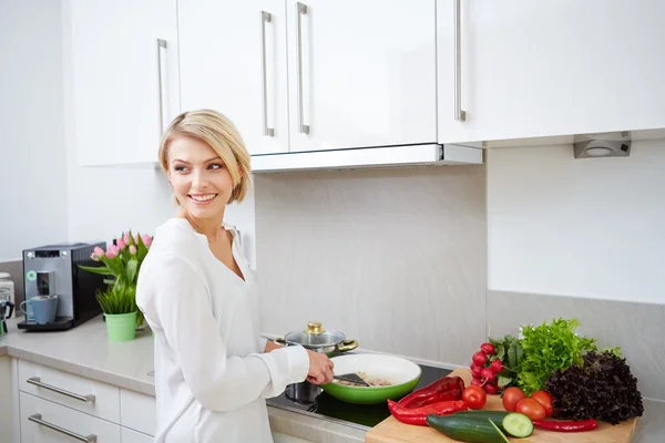 Blonde woman using a tablet computer to cook