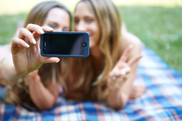 Two happy women friends sharing social media