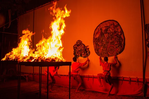 Rachaburi, Thailand - April 14, 2015: Youth show perform Grand Shadow Play in night at Wat Khanon.Rachaburi, Thailand.The ancient performing art involves manipulating puppets of cowhide with coconut shell fire. in front of a backlit white screen.