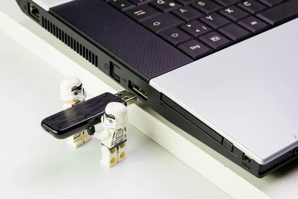 Lego star wars stormtrooper plug the flash drive into notebook.