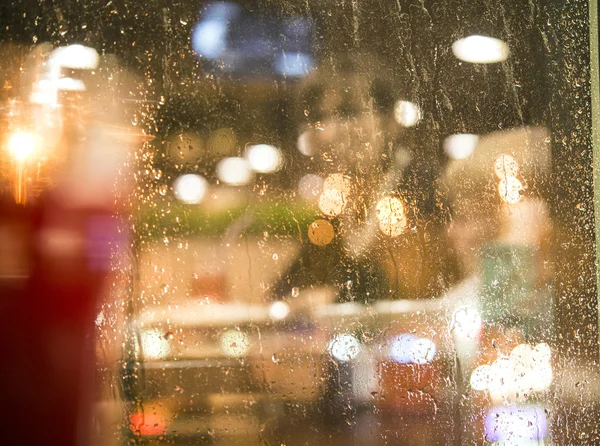 Reflection in the window. window in rain drops with views of the city at night. blurred background